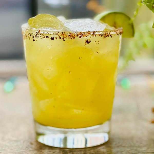 A Digger's Ales N' Eats margarita with a spiced rim, ice, and lime wedges.